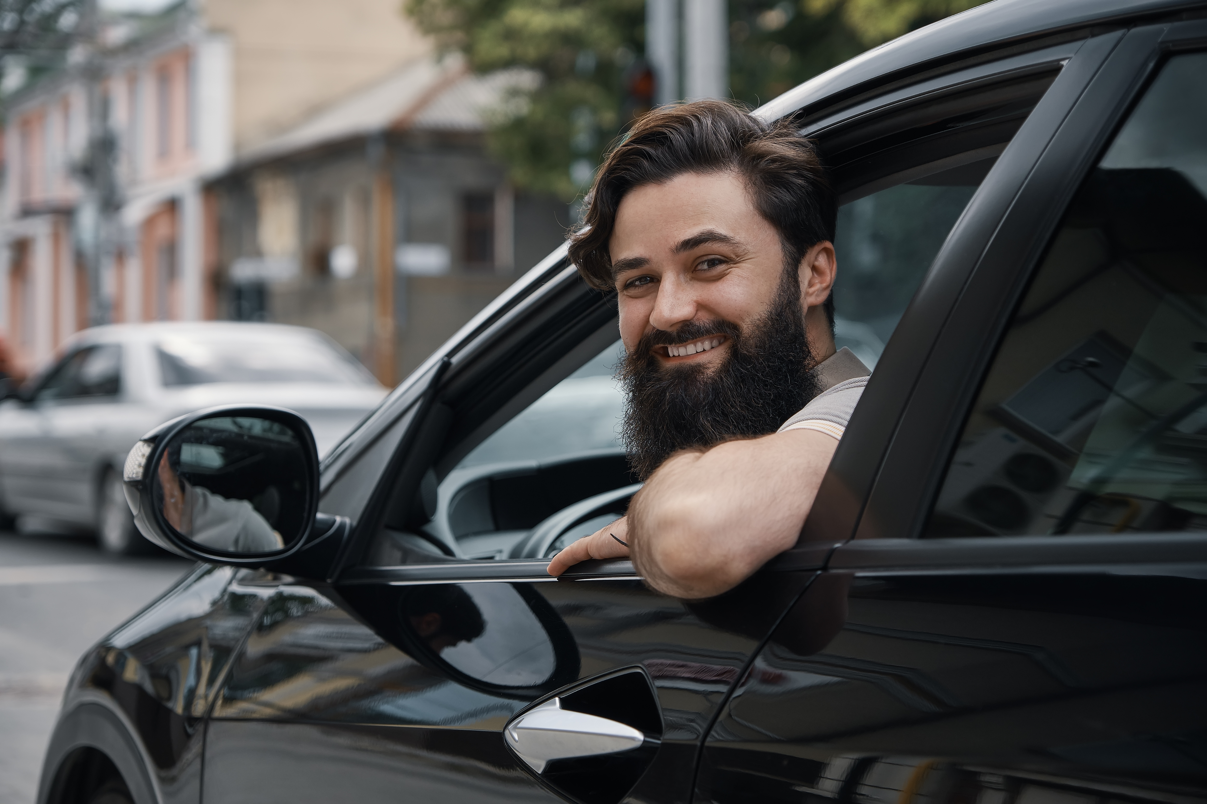 Man smiling while driving a car